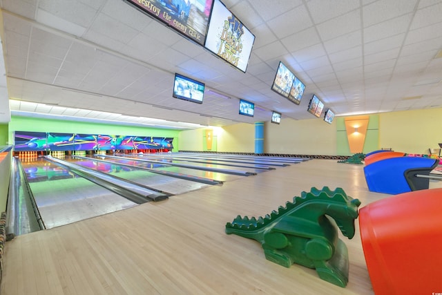 rec room featuring bowling, wood finished floors, and a drop ceiling