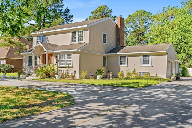 3763 Annandale Dr, Myrtle Beach, SC 29577 - view of front of house with stucco siding, driveway, a chimney, and a front yard