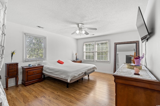 3763 Annandale Dr, Myrtle Beach, SC 29577 - bedroom with visible vents, a textured ceiling, light wood-style floors, baseboards, and ceiling fan