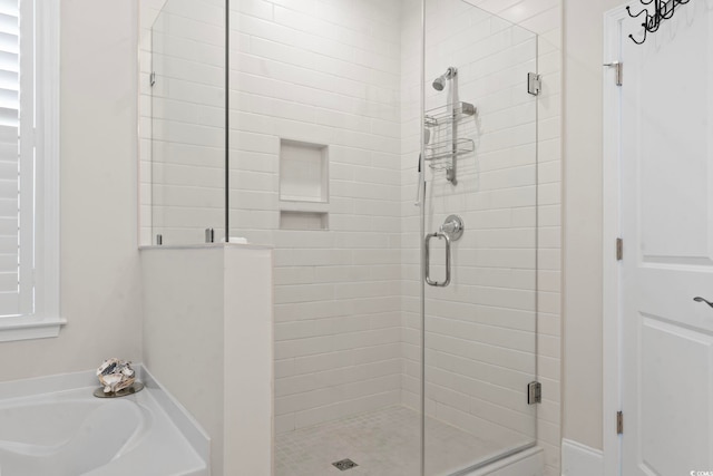 bathroom featuring a bath and a shower stall