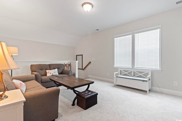 living area with lofted ceiling, light colored carpet, baseboards, and visible vents