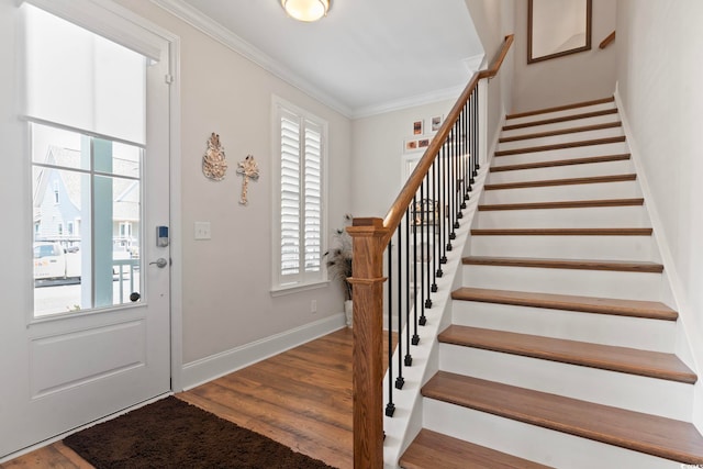 foyer entrance featuring crown molding, stairway, wood finished floors, and baseboards