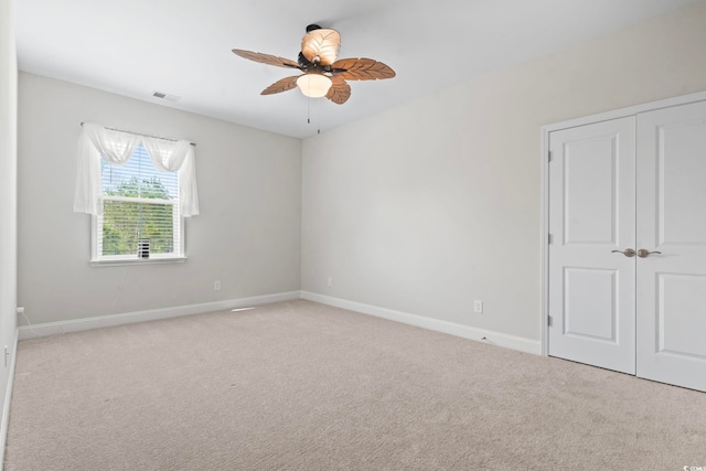 spare room with visible vents, baseboards, a ceiling fan, and carpet floors