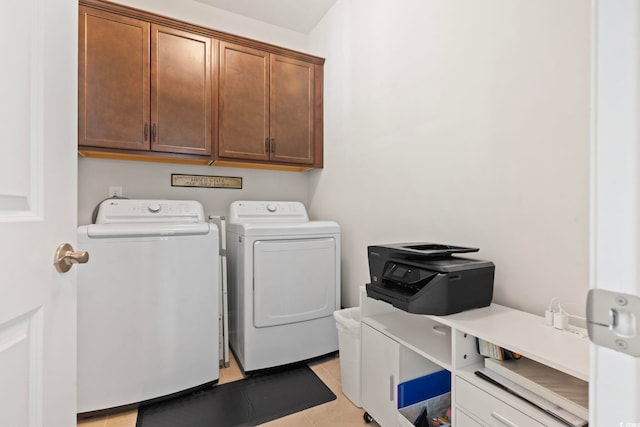 laundry area with washer and clothes dryer, light tile patterned floors, and cabinet space