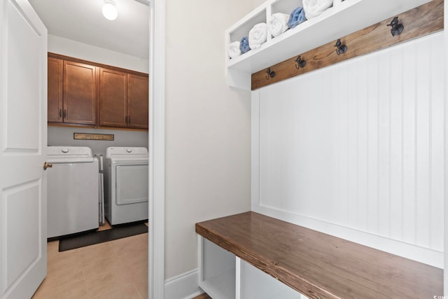 washroom with light tile patterned floors, cabinet space, and independent washer and dryer