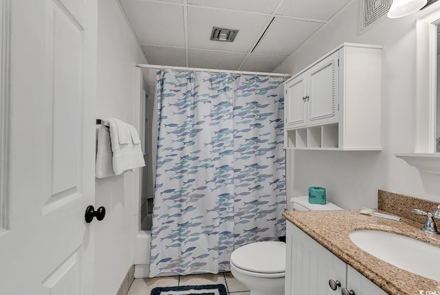 full bathroom featuring tile patterned floors, visible vents, toilet, a drop ceiling, and vanity