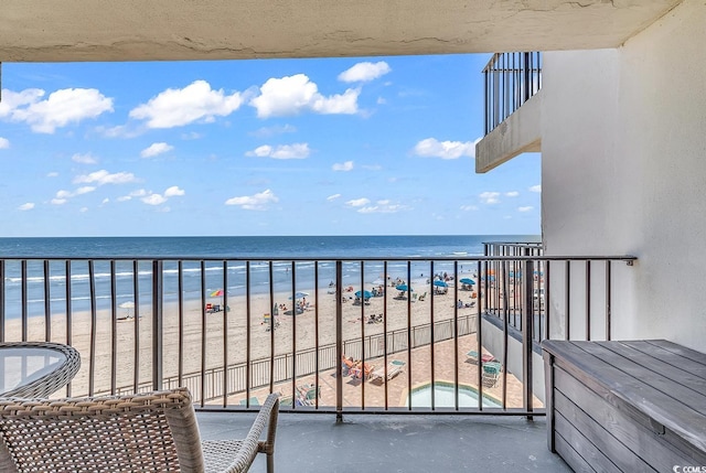 balcony featuring a beach view and a water view