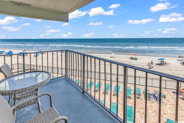 balcony featuring a view of the beach and a water view