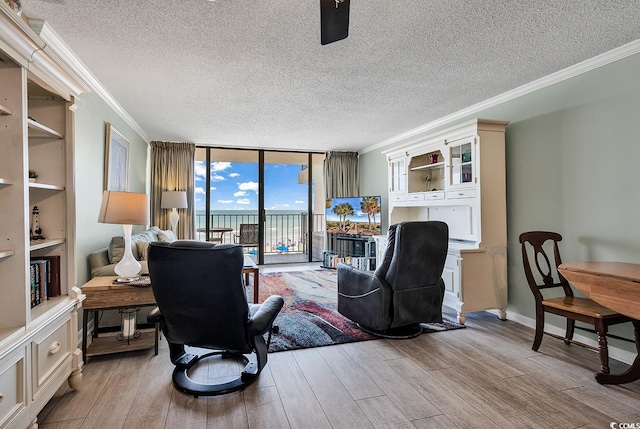 office space featuring light wood-style flooring, a wall of windows, and ornamental molding