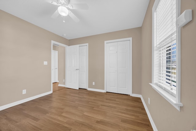 4938 Trooper Ln, Loris, SC 29569 - unfurnished bedroom with multiple closets, wood finished floors, baseboards, and ceiling fan