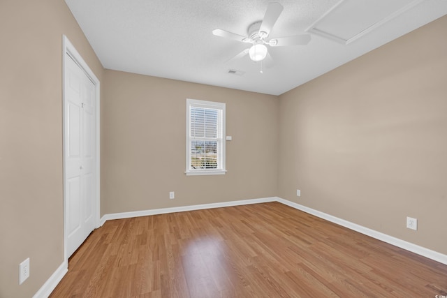 4938 Trooper Ln, Loris, SC 29569 - unfurnished bedroom with light wood-style floors, baseboards, a ceiling fan, a textured ceiling, and a closet