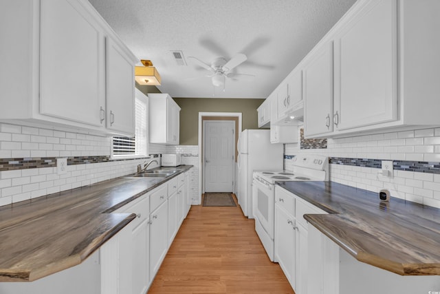 4938 Trooper Ln, Loris, SC 29569 - kitchen with white appliances, dark countertops, a ceiling fan, under cabinet range hood, and a sink