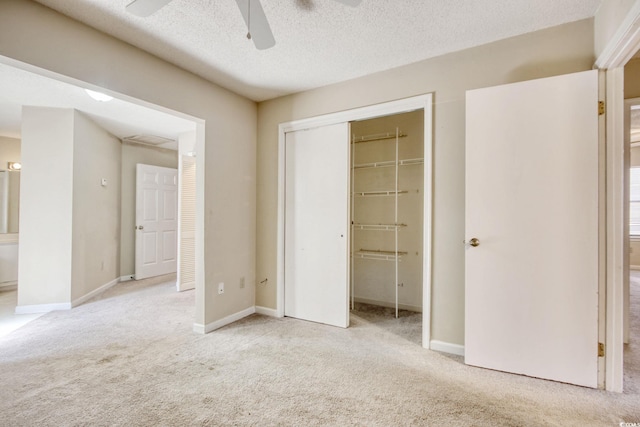 unfurnished bedroom featuring a closet, a textured ceiling, baseboards, and carpet floors