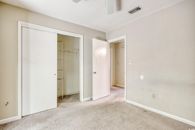 unfurnished bedroom with carpet, baseboards, visible vents, a closet, and a textured ceiling