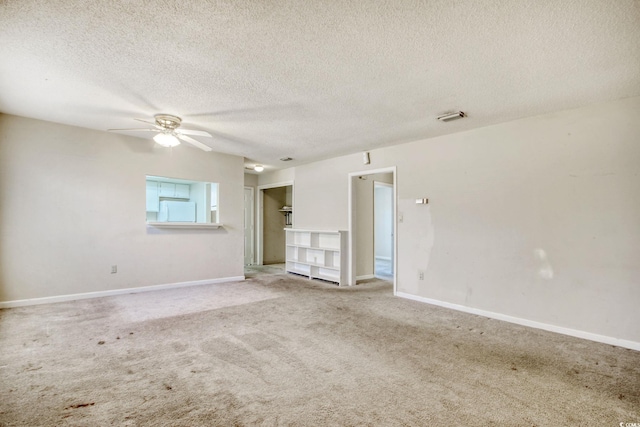 empty room featuring visible vents, baseboards, ceiling fan, carpet floors, and a textured ceiling