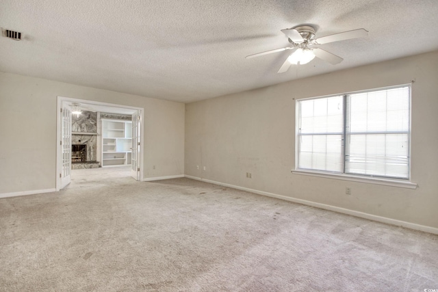 unfurnished room featuring baseboards, carpet, visible vents, and ceiling fan