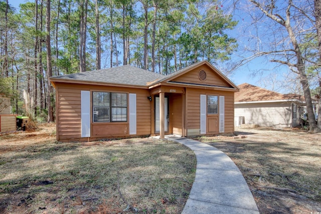 view of front of home featuring a front lawn and a shingled roof