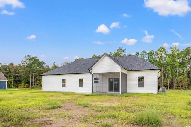 rear view of house with a yard, central AC unit, ceiling fan, and a shingled roof