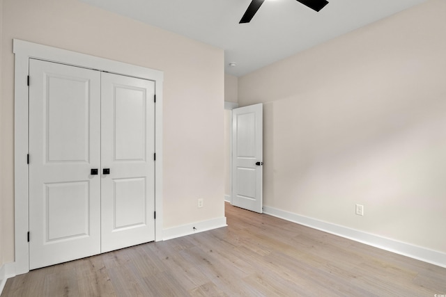 unfurnished bedroom with a closet, baseboards, light wood finished floors, and ceiling fan