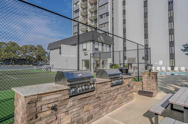 view of patio featuring grilling area, an outdoor kitchen, and fence