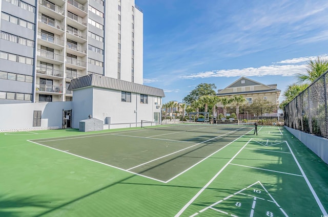 surrounding community featuring a tennis court, shuffleboard, and fence