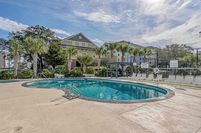 community pool with a patio area, fence, and a pergola