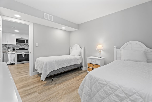 bedroom featuring light wood-type flooring, visible vents, and recessed lighting