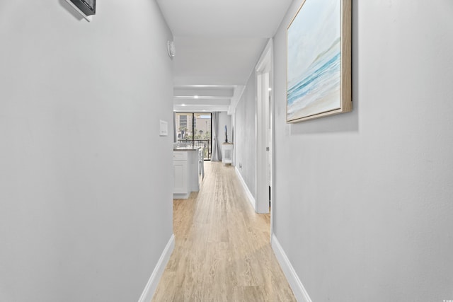 hallway with baseboards and light wood-style flooring