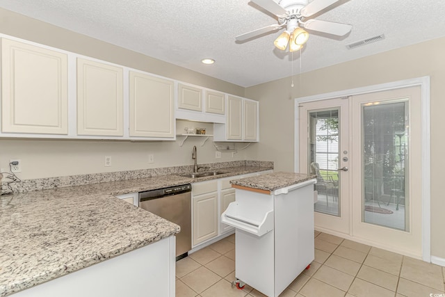 kitchen with light tile patterned flooring, visible vents, stainless steel dishwasher, and a sink