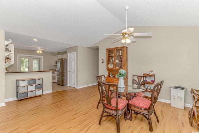 dining space with vaulted ceiling, baseboards, light wood finished floors, and ceiling fan