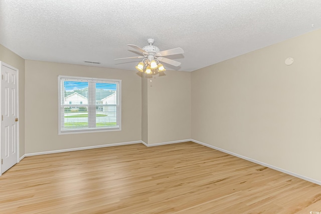 unfurnished room featuring light wood finished floors, visible vents, baseboards, ceiling fan, and a textured ceiling