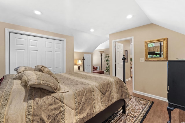 bedroom featuring wood finished floors, recessed lighting, a closet, baseboards, and lofted ceiling