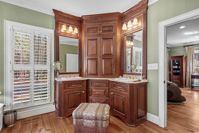 full bathroom with double vanity, wood finished floors, visible vents, and ornamental molding