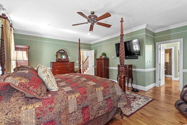 bedroom featuring crown molding, wood finished floors, baseboards, and ceiling fan