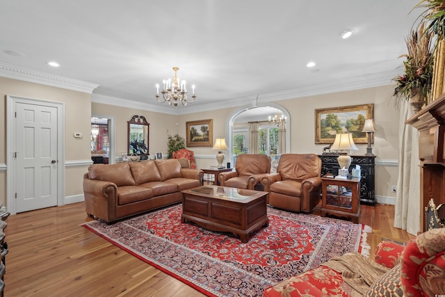 living room with a chandelier, recessed lighting, crown molding, and light wood-type flooring