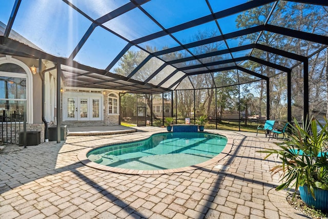 pool with glass enclosure, a patio area, and french doors