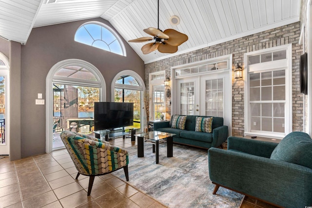 tiled living room featuring brick wall, high vaulted ceiling, and a ceiling fan