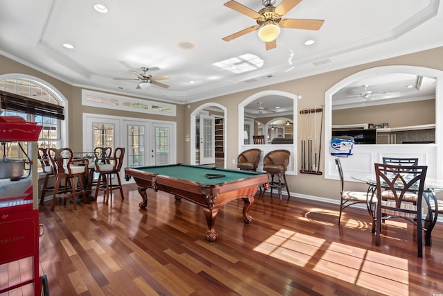 game room featuring crown molding, a tray ceiling, a ceiling fan, and wood finished floors