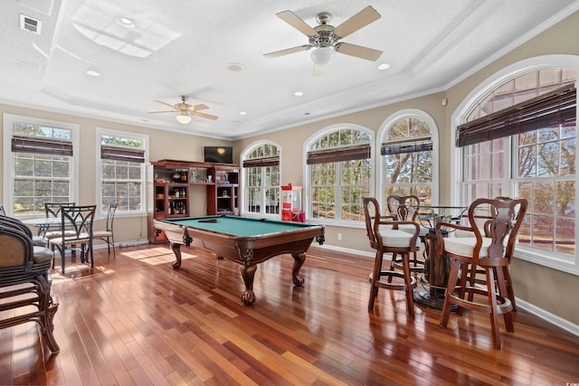 rec room with a raised ceiling, plenty of natural light, and hardwood / wood-style flooring