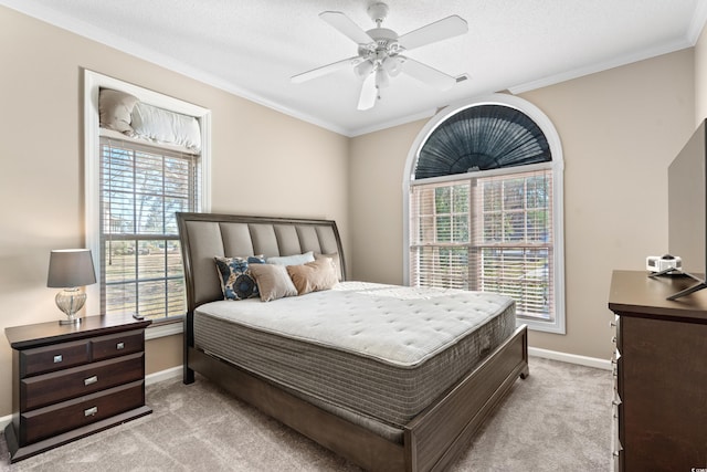 bedroom with light colored carpet, ceiling fan, baseboards, and ornamental molding