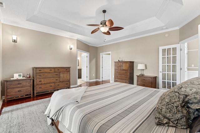 bedroom with visible vents, a raised ceiling, and wood finished floors