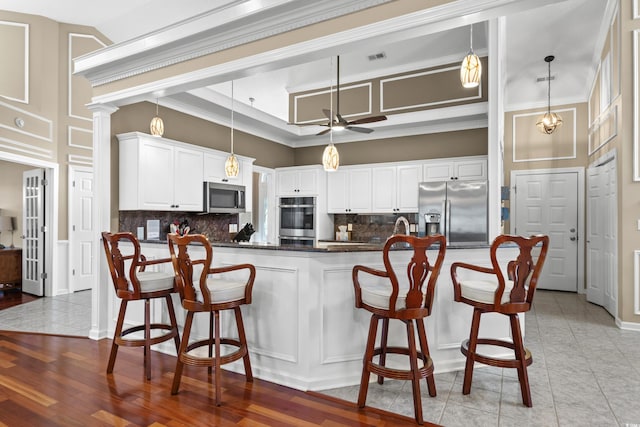 kitchen with dark countertops, backsplash, crown molding, ceiling fan, and appliances with stainless steel finishes