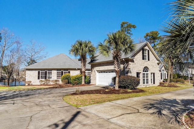 view of front of house featuring brick siding, driveway, an attached garage, and a shingled roof