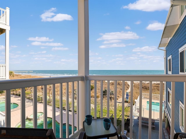 balcony with a water view and a beach view