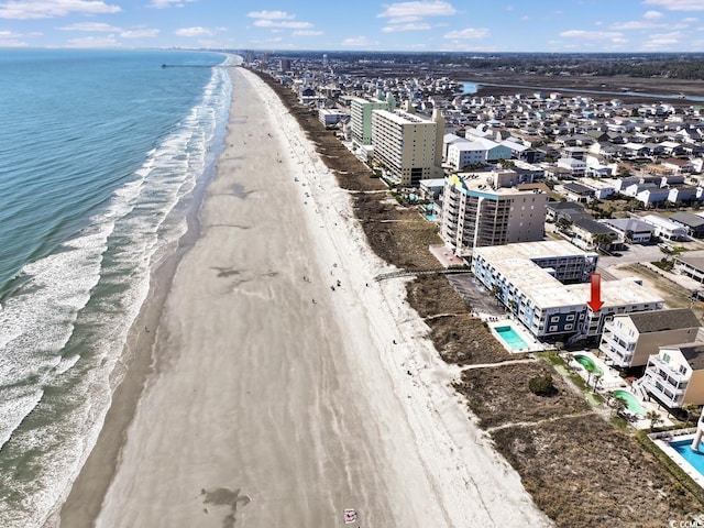 drone / aerial view featuring a water view and a beach view