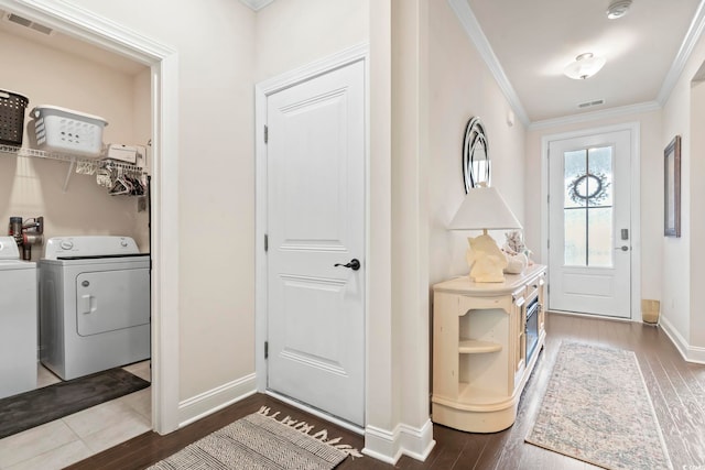 foyer entrance featuring visible vents, washing machine and dryer, crown molding, and wood finished floors
