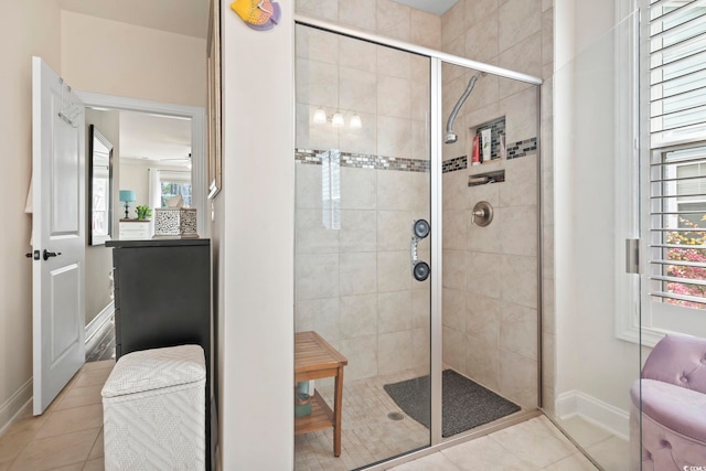 full bath with tile patterned flooring, a shower stall, and baseboards