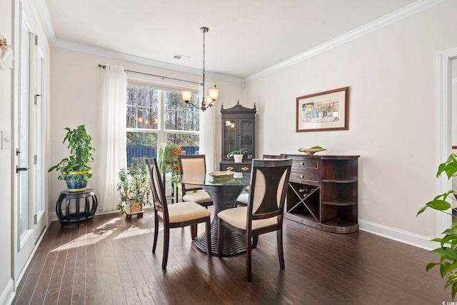 dining room featuring visible vents, baseboards, dark wood finished floors, an inviting chandelier, and ornamental molding