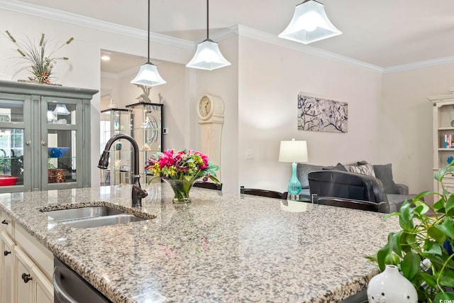 kitchen with ornamental molding, a sink, light stone counters, open floor plan, and hanging light fixtures