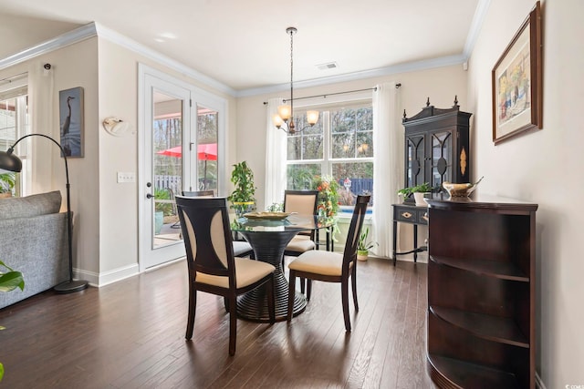 dining room featuring visible vents, ornamental molding, dark wood finished floors, baseboards, and a chandelier